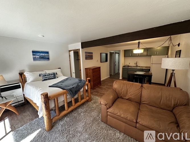 A bedroom with a bed, couch, and a lamp.