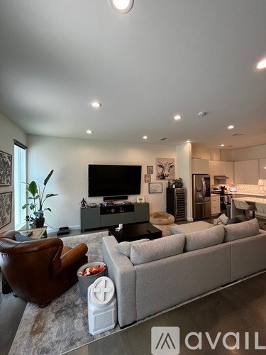 A living room with a grey couch and a brown leather chair.