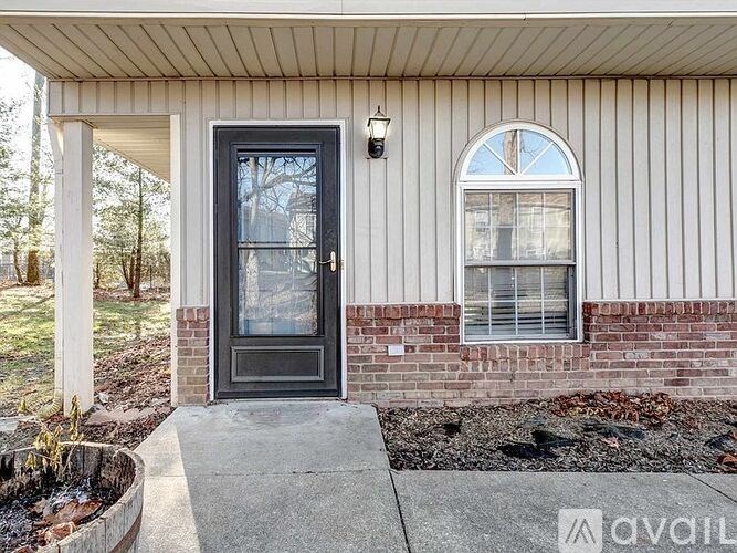 A house with a black door and a window is for sale.