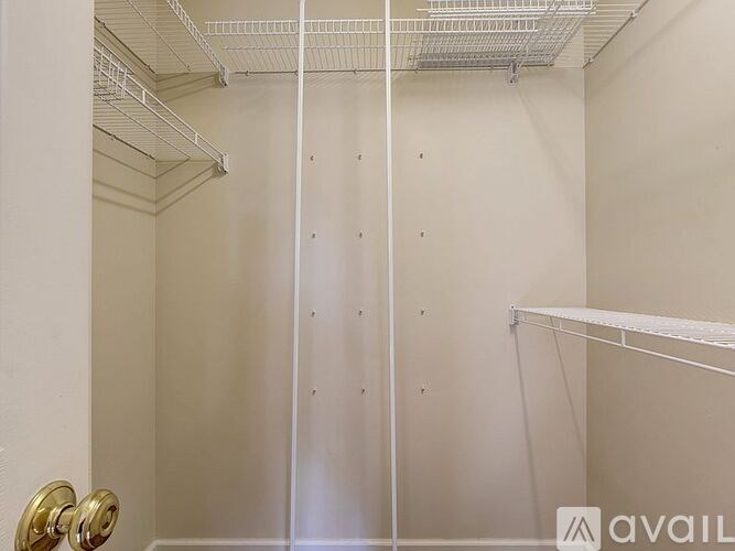 A white walk-in closet with a metal rod for hanging clothes.