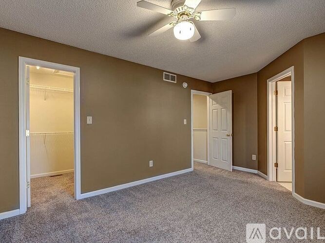 A room with a ceiling fan and carpeted floor.