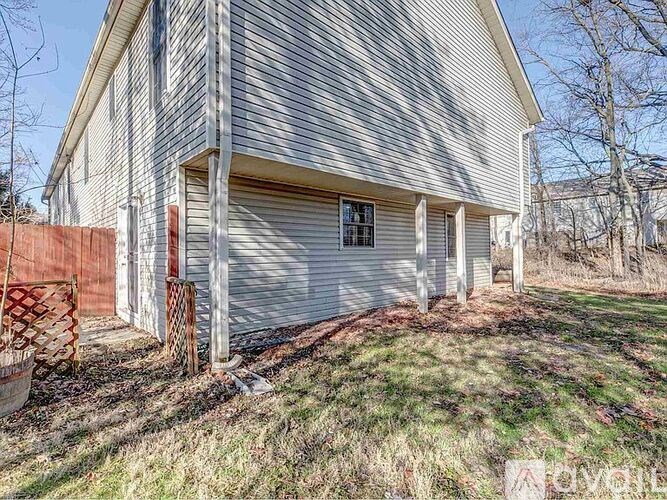 A house with a grey siding and a closed grey garage door.