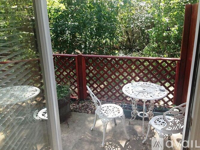 A patio with a table and chairs is visible through a glass door.