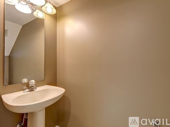 A white sink with a silver faucet is under a mirror in a bathroom.