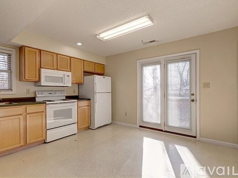 A kitchen with wooden cabinets and white appliances.
