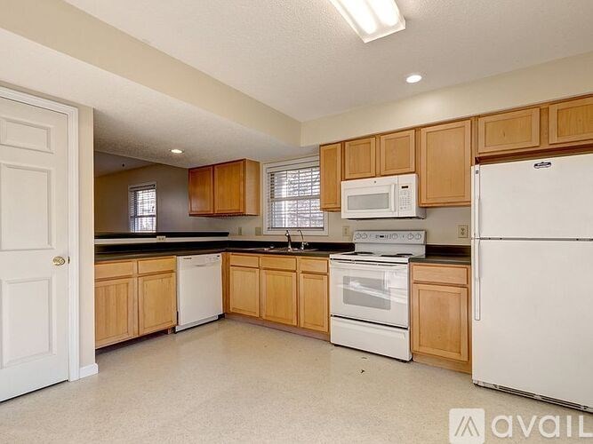 A kitchen with wooden cabinets and white appliances.