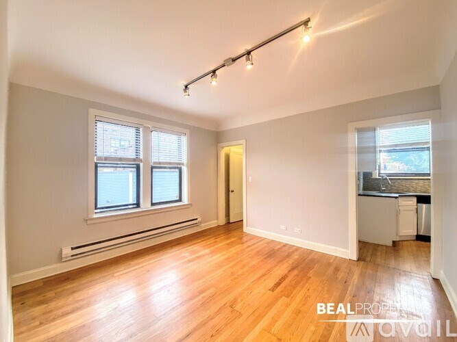 A room with wooden floors and a window with blinds.