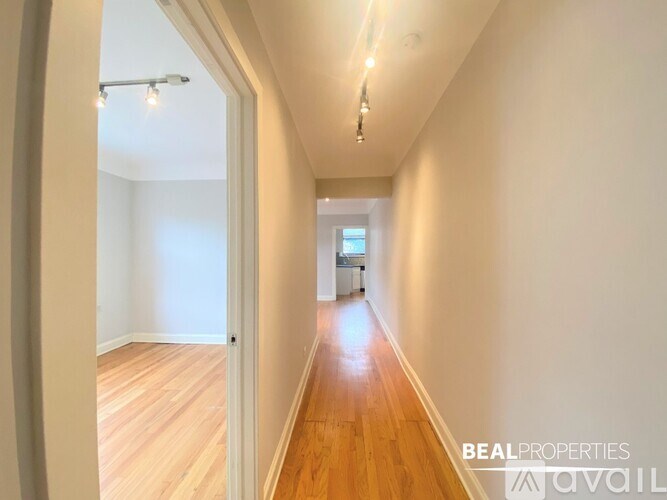 A long hallway with wooden floors and white walls.