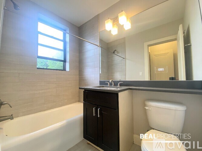 A bathroom with a tub, toilet, and sink.