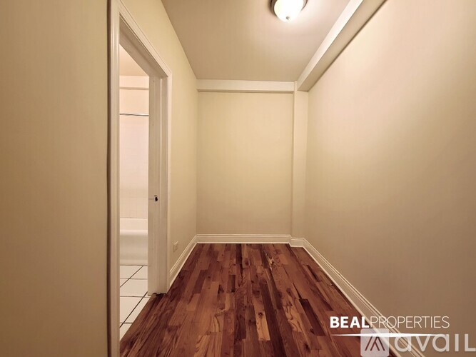 A hallway with wooden floors and white walls.