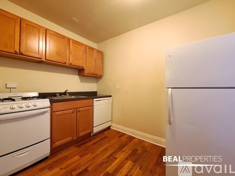A kitchen with wooden cabinets and a white stove top oven.