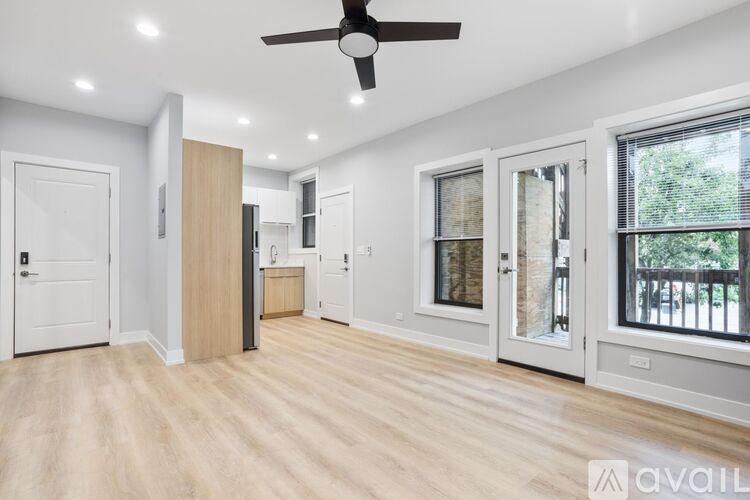 A spacious room with a ceiling fan and lighting fixtures.