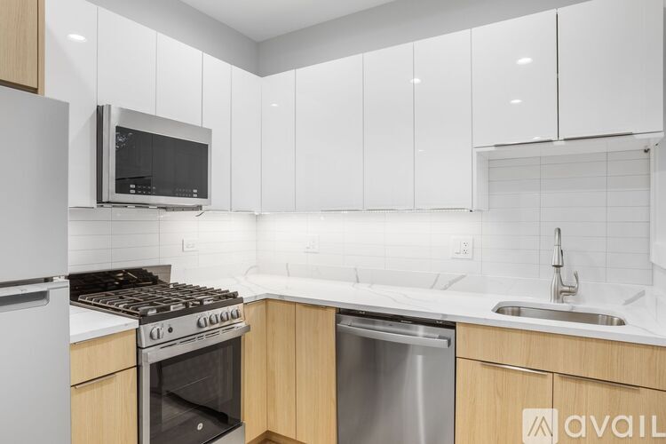 A kitchen with white cabinets and a stainless steel dishwasher.