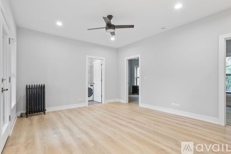 A spacious room with a ceiling fan and lighting fixtures.