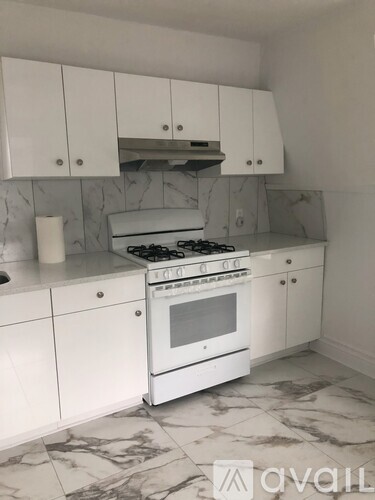 A kitchen with a white stove and cabinets.