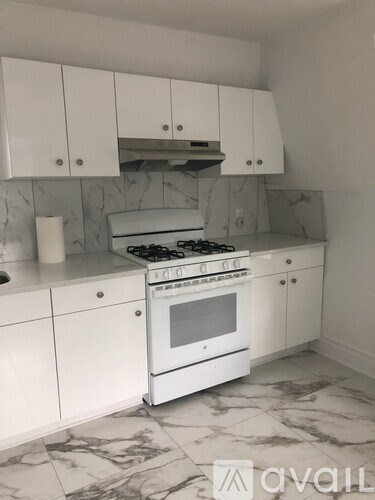 A kitchen with a white stove and cabinets.