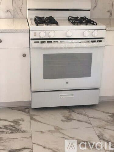 A white oven with a stove on top is in a kitchen.