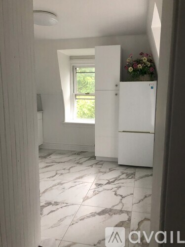 A kitchen with a white fridge and a window.