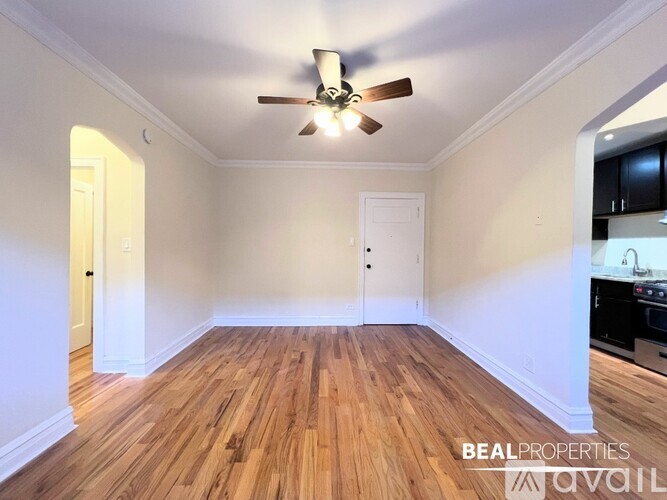 A room with a ceiling fan and wooden flooring.
