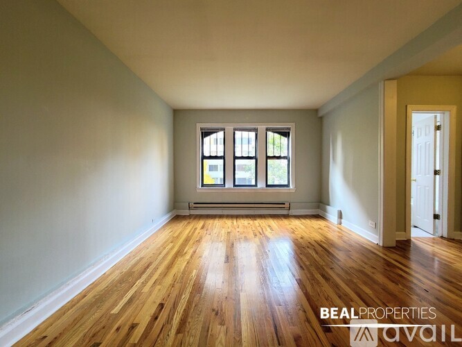A room with wooden floors and a window with three panes.