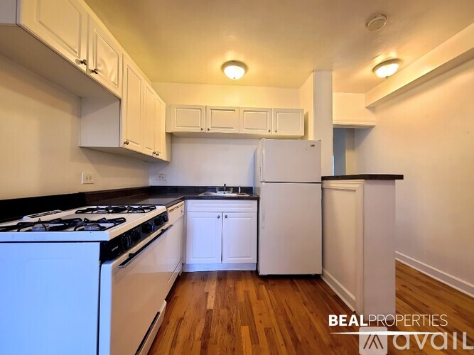 A kitchen with white appliances and cabinets.