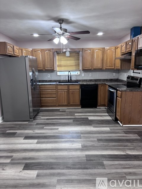 A kitchen with wooden cabinets and a black countertop.
