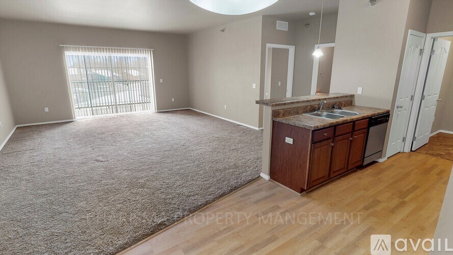 A spacious living room with a kitchenette and a large window.