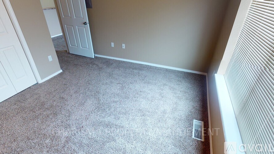 A room with a carpeted floor and a door.