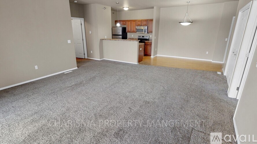 A spacious living area with a kitchenette in the background.