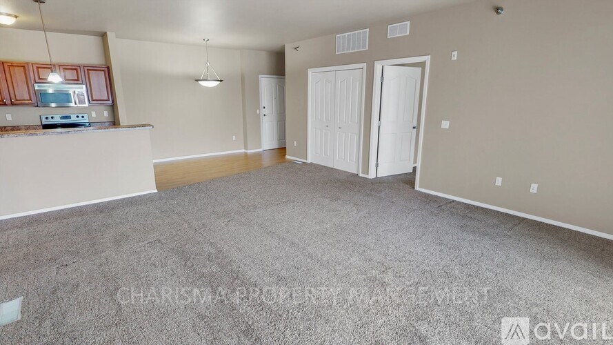 A spacious living room with a kitchenette in the background.