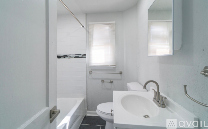 A white bathroom with a toilet, sink, and bathtub.