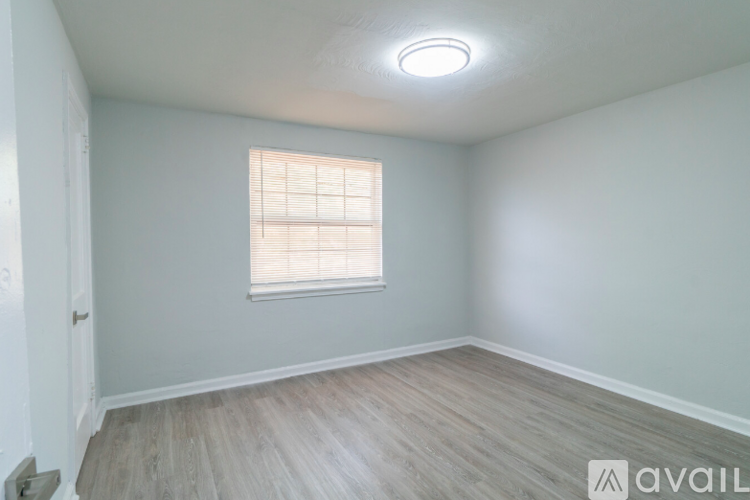 A room with a window and wooden flooring.