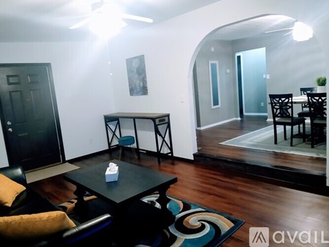 A living room with a black table and chairs.