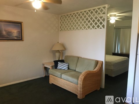 A living room with a couch, lamp, and a painting on the wall.