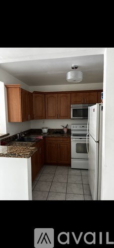 A kitchen with wooden cabinets and a white refrigerator.