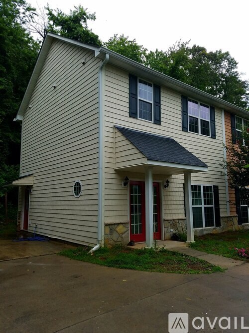 A house with a red door and a window with a black frame.