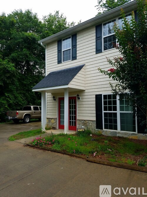 A house with a red door and a truck parked in the driveway.