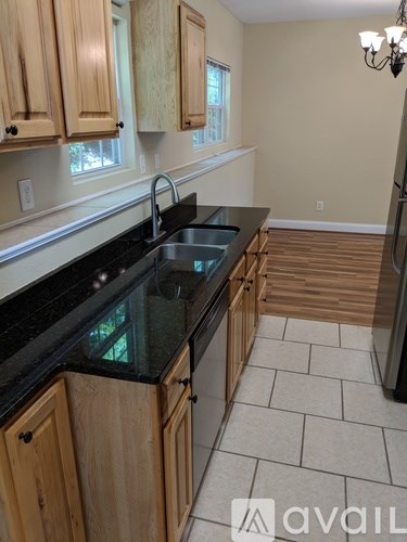 A kitchen with wooden cabinets and black countertops.