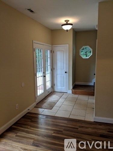 A hallway with a white door and a brown floor.