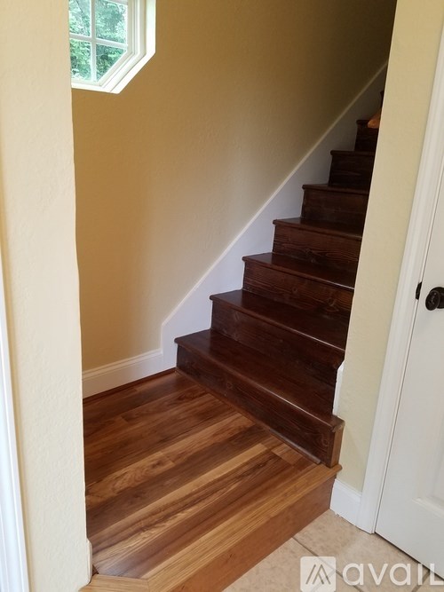 A wooden staircase with a white door on the right.