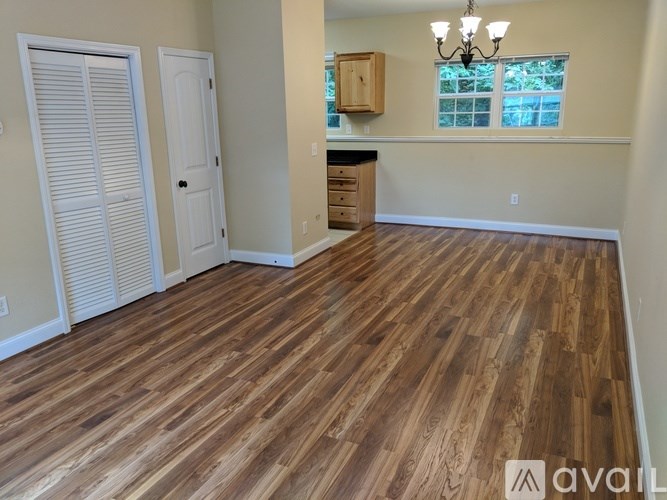 A room with wooden flooring and a chandelier.
