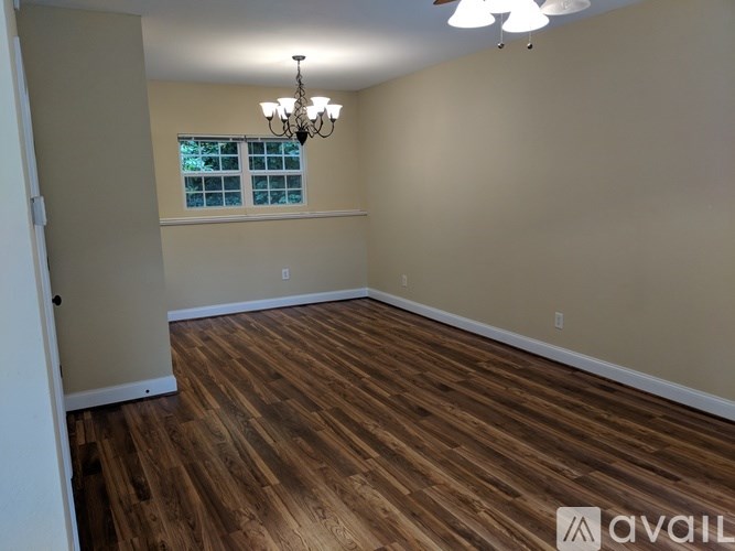 A room with wooden flooring and a chandelier.