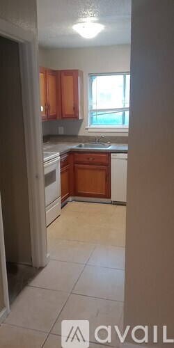 A kitchen with wooden cabinets and a window.