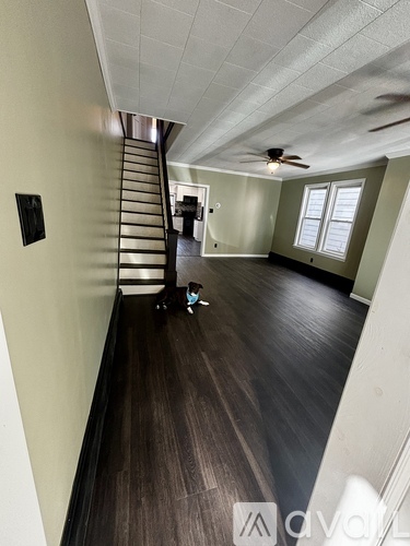 A room with a staircase and a ceiling fan.