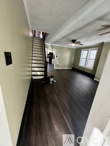A room with a staircase and a ceiling fan.