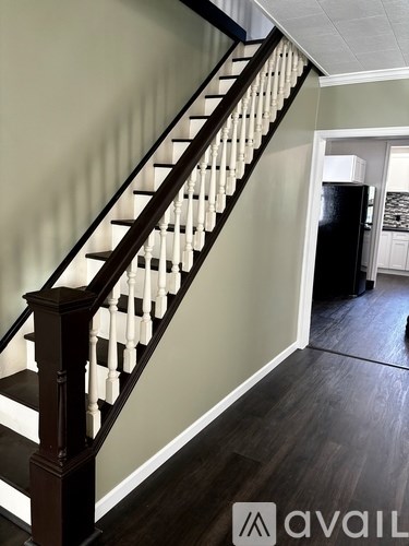 A staircase with a dark wood banister and white balusters.
