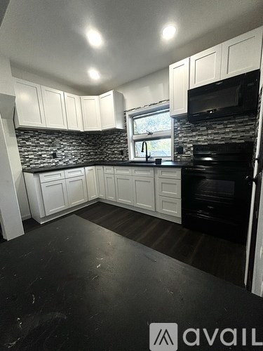 A kitchen with black countertops and white cabinets.