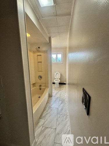 A bathroom with a tub, toilet and sink.