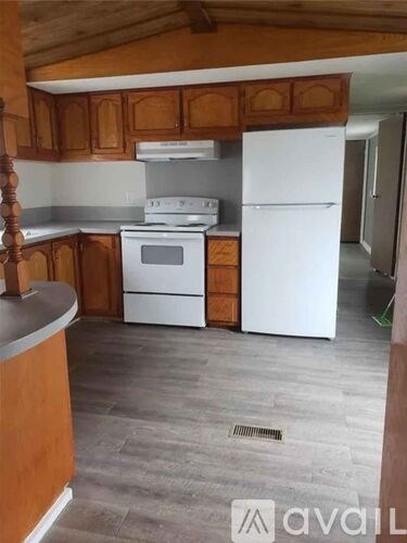 A kitchen with wooden cabinets and a white fridge.