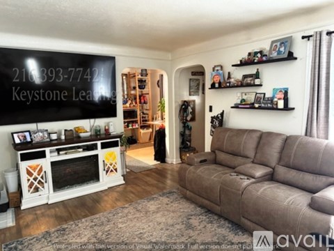 A living room with a grey couch and a fireplace.